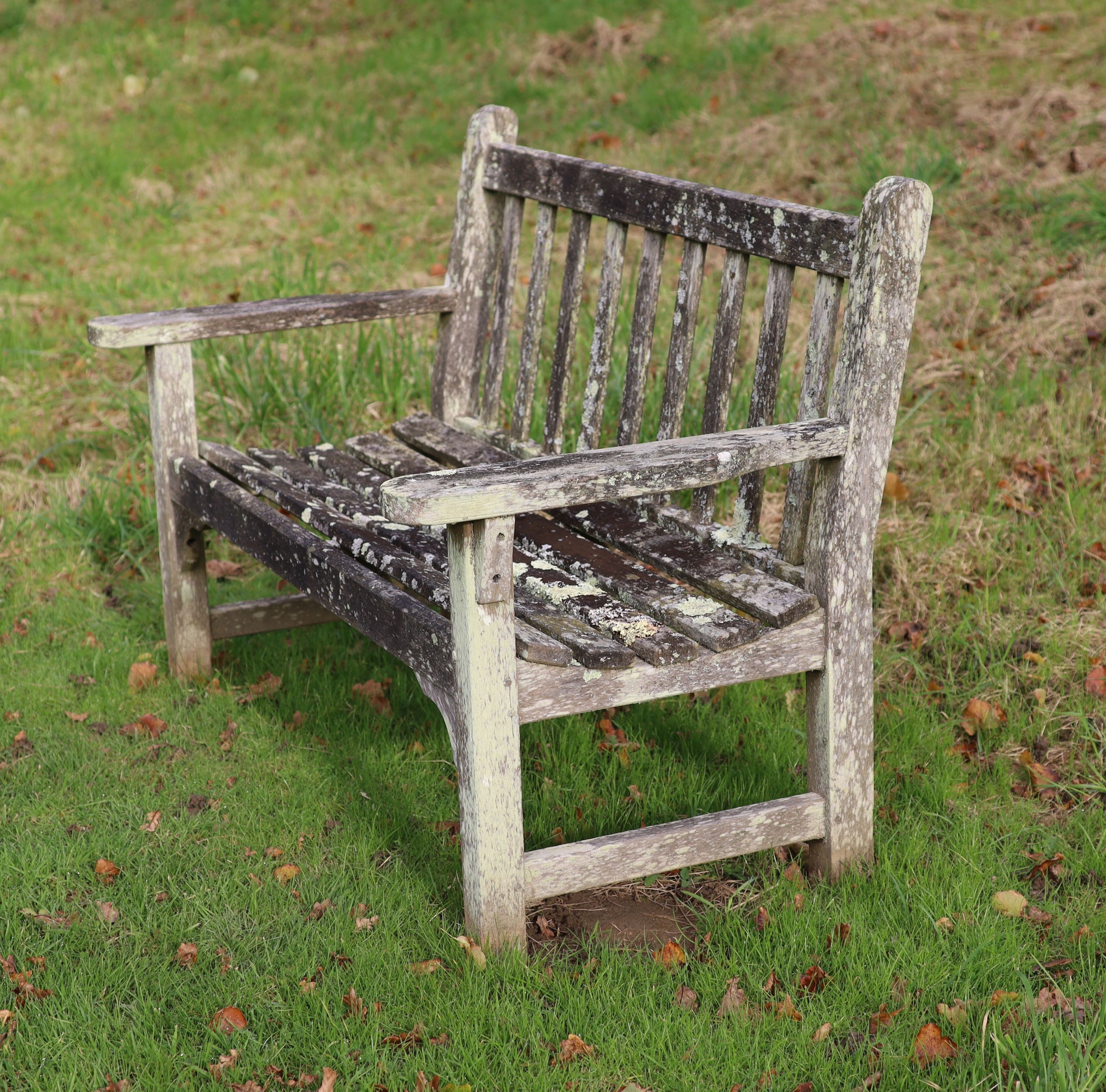A pair of weathered teak garden benches, width 158cm